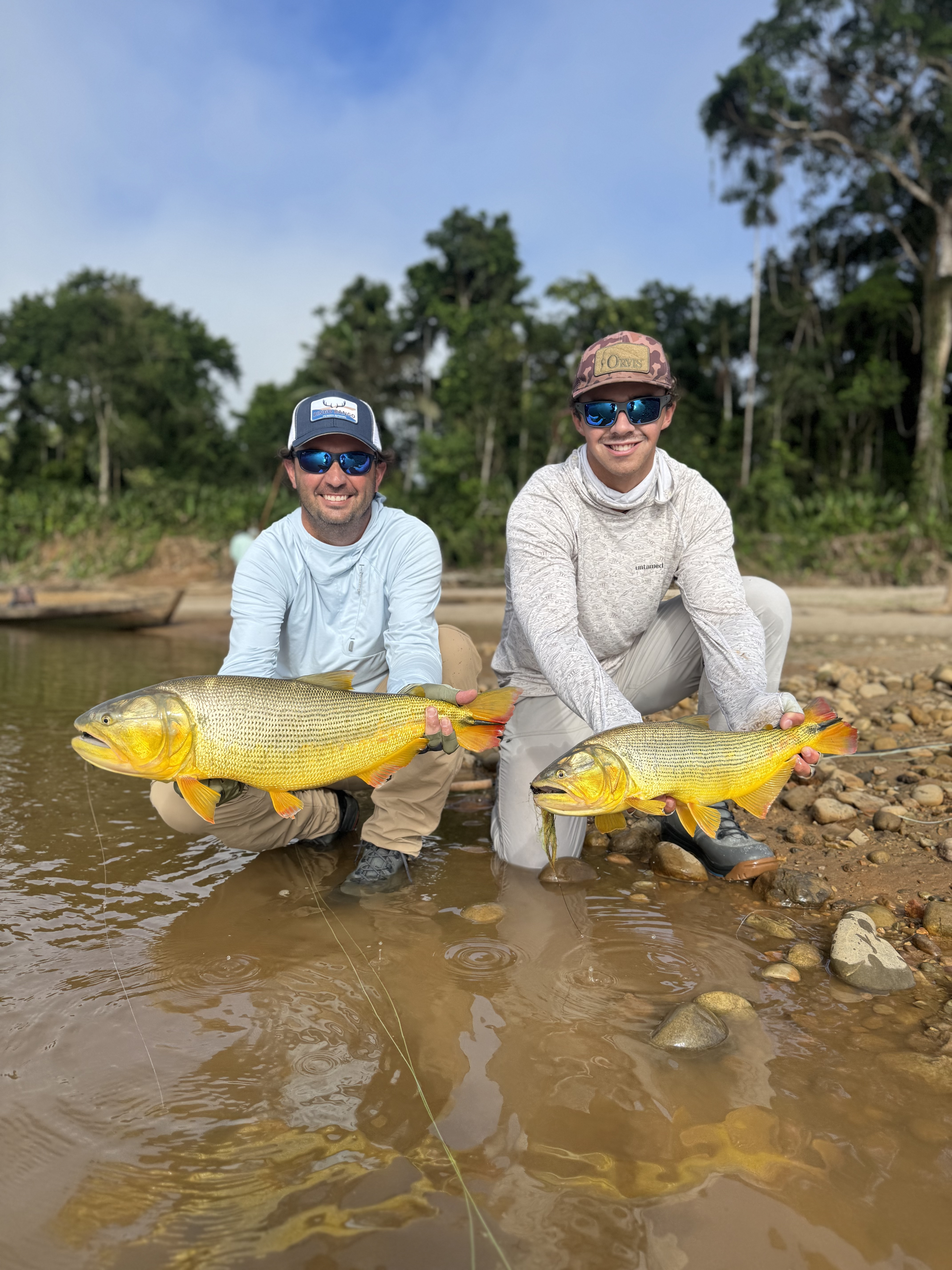 Father and son with one dorado each on crystal clear waters