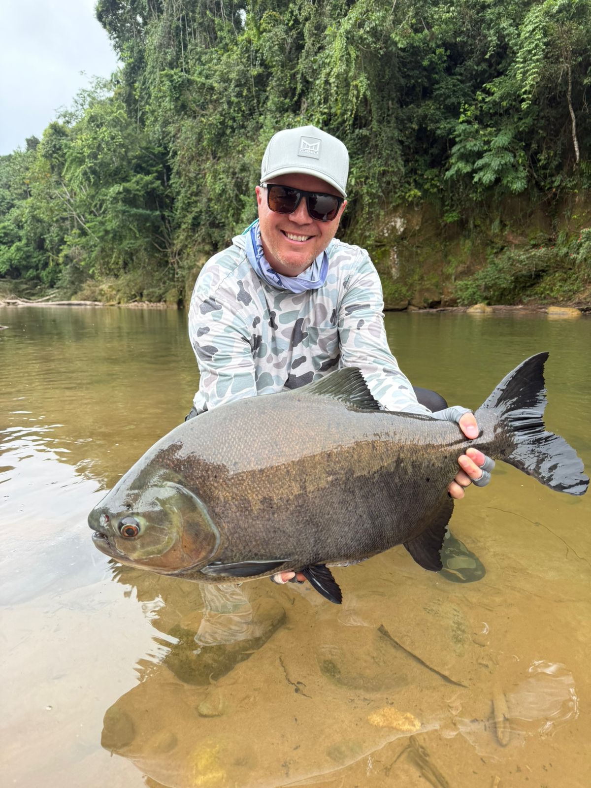 Angler with pacú on crystal clear waters